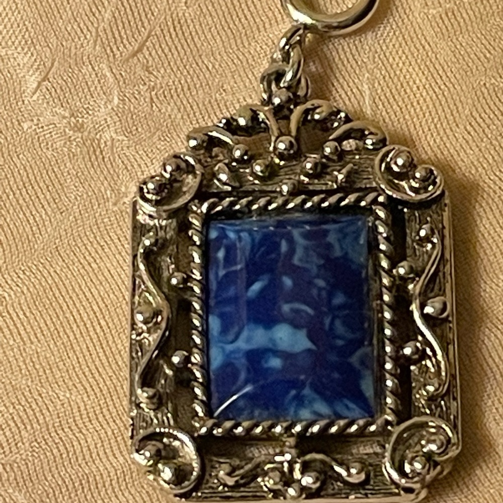 Chunky silver colored pendant w/blue marbled stone middle on 1 side & cross back